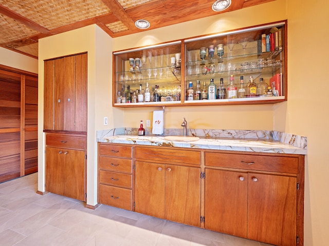 bar featuring tile counters, sink, and light tile patterned flooring