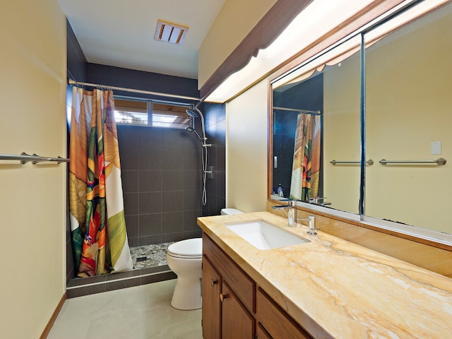 bathroom with curtained shower, vanity, and toilet