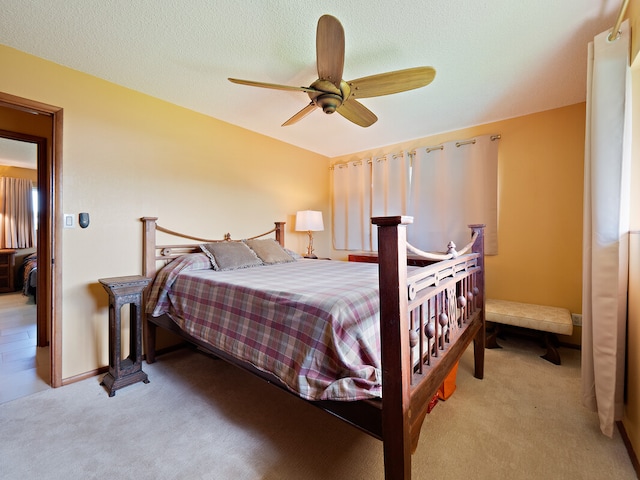 carpeted bedroom featuring ceiling fan and a textured ceiling