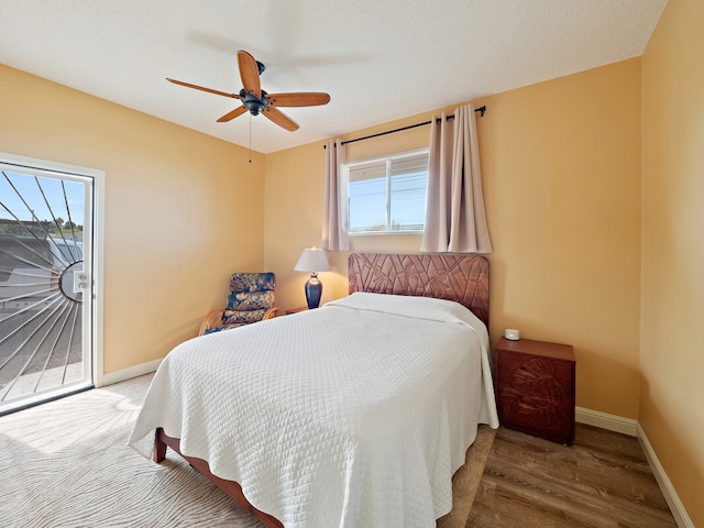 bedroom with ceiling fan, hardwood / wood-style flooring, and a textured ceiling