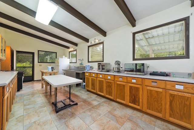 kitchen featuring vaulted ceiling with beams and white refrigerator