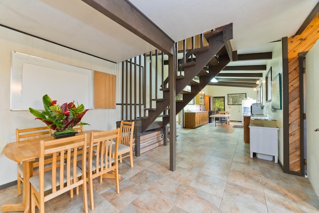 dining room featuring lofted ceiling with beams