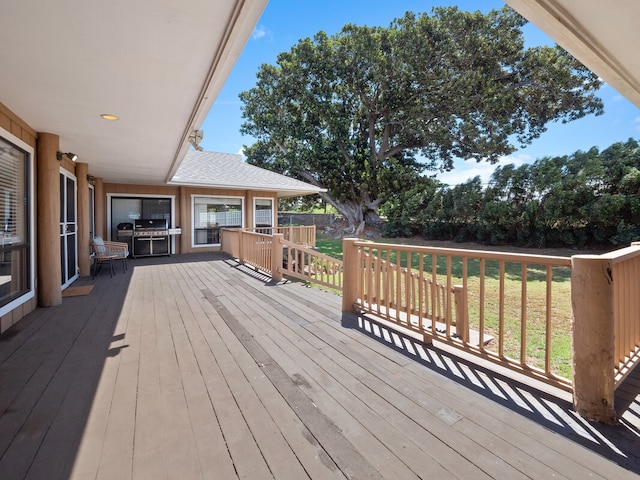 wooden deck featuring area for grilling and a lawn