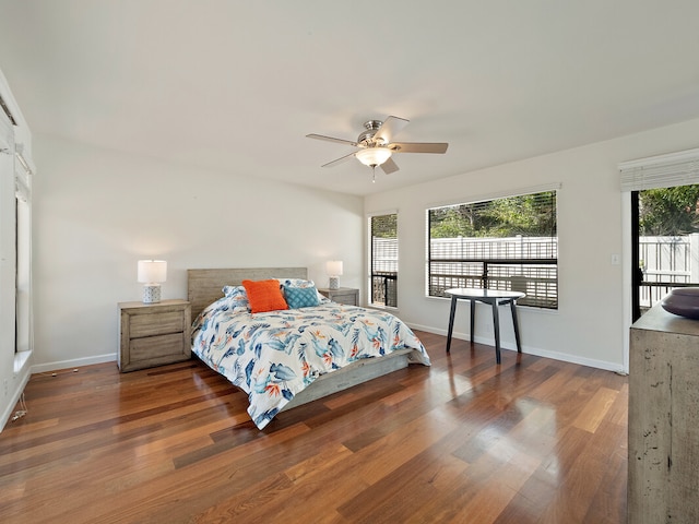 bedroom with ceiling fan, dark wood-type flooring, and access to exterior