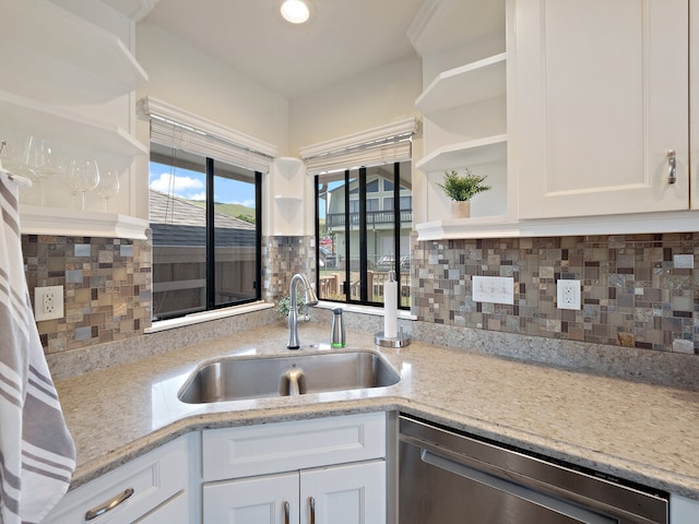 kitchen with dishwasher, backsplash, sink, and white cabinetry