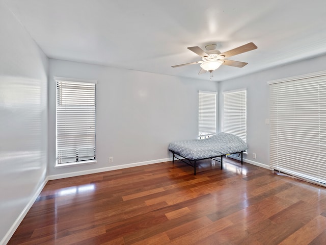 living area with ceiling fan and dark hardwood / wood-style flooring