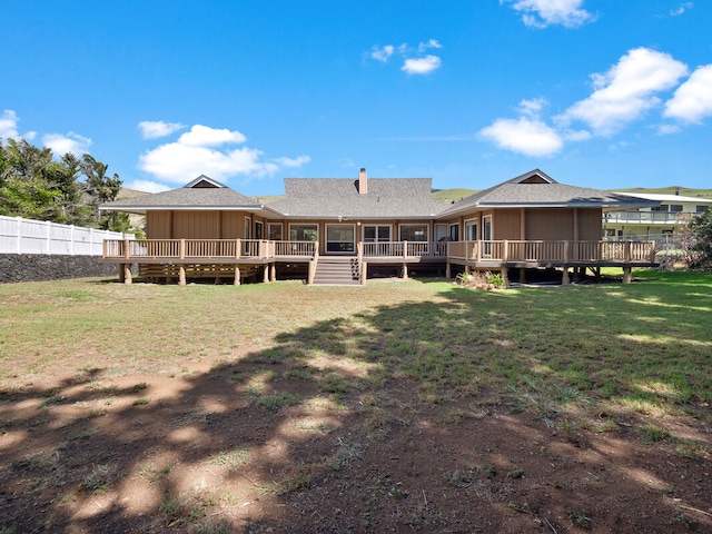 back of house featuring a lawn and a deck