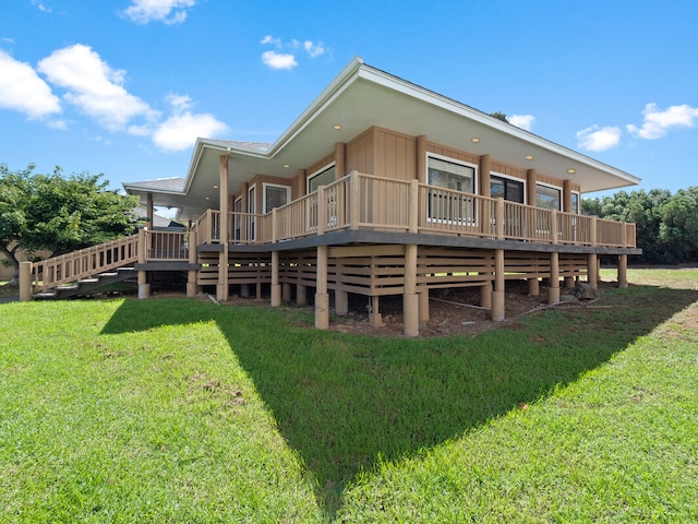 rear view of house featuring a wooden deck and a lawn