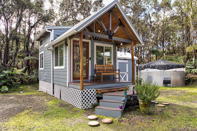 view of front of property featuring a storage unit and a wooden deck