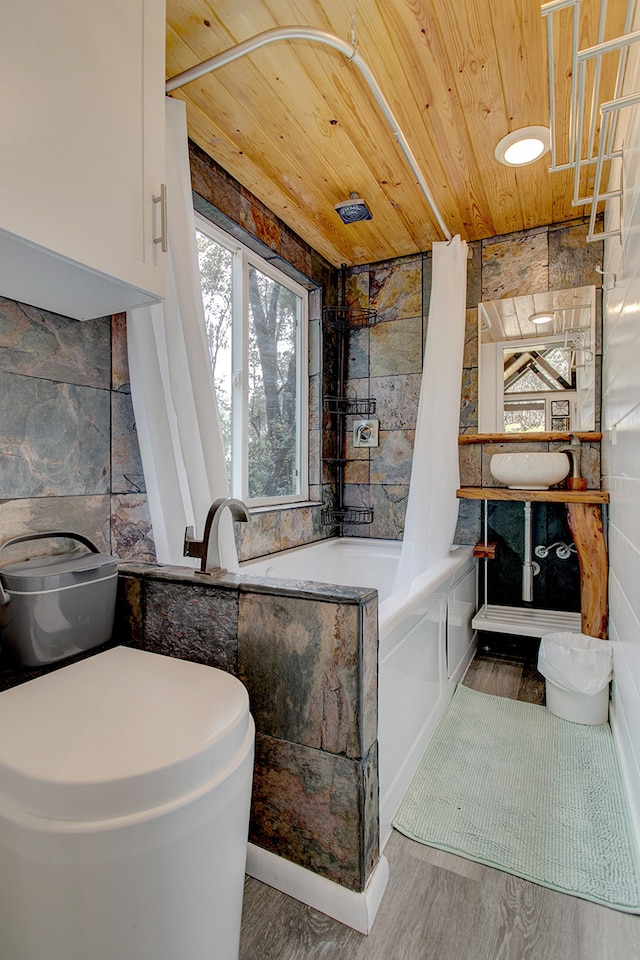 bathroom with wood-type flooring, wood ceiling, tile walls, and shower / bath combo with shower curtain