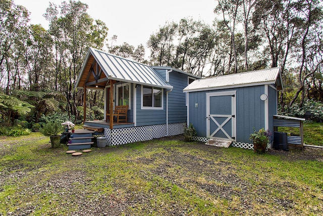 back of house featuring a lawn and a shed