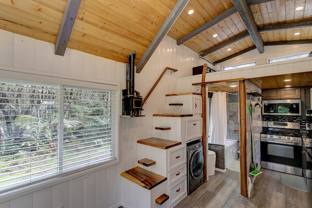 kitchen featuring wood ceiling, light wood-type flooring, washer / clothes dryer, stainless steel appliances, and vaulted ceiling with beams