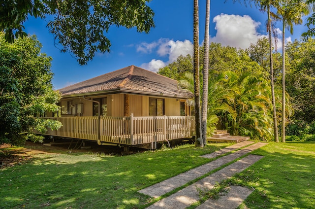 rear view of property with a lawn and a deck