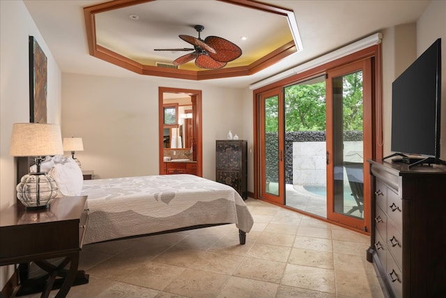 bedroom featuring a raised ceiling, ensuite bath, ceiling fan, and access to exterior