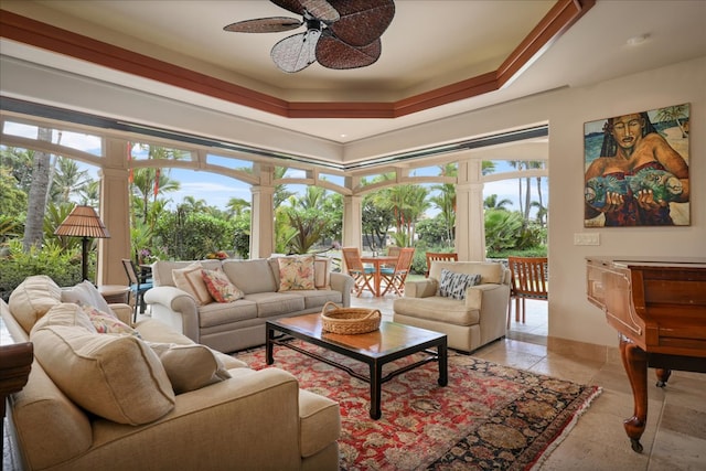 tiled living room featuring ceiling fan and a raised ceiling