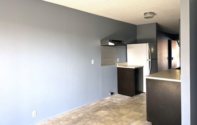 kitchen featuring wall chimney exhaust hood and a textured ceiling