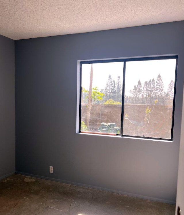 spare room featuring plenty of natural light and a textured ceiling