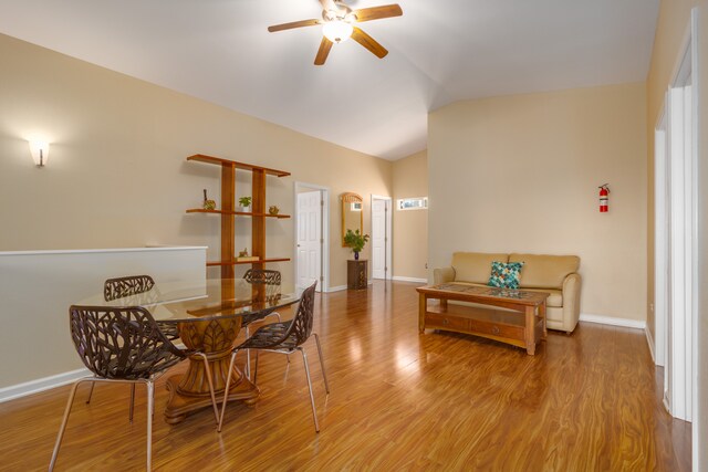 dining area with ceiling fan, light hardwood / wood-style flooring, and vaulted ceiling