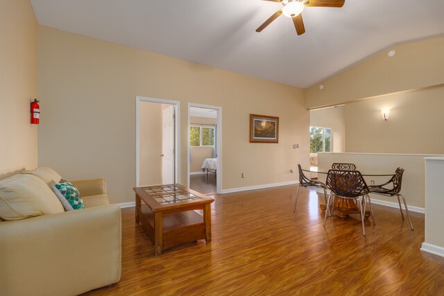 living room with hardwood / wood-style flooring, ceiling fan, and lofted ceiling