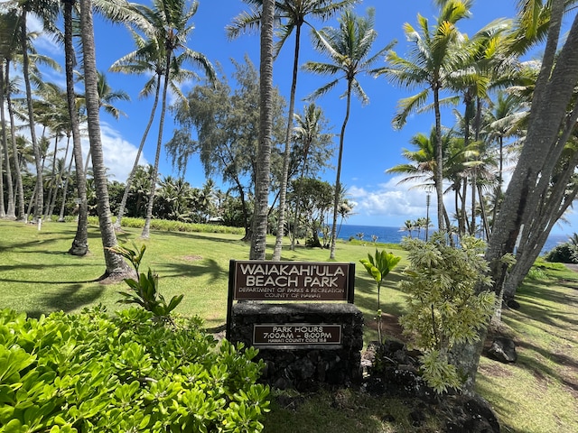 view of property's community featuring a lawn and a water view