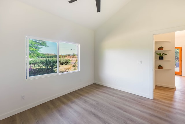 empty room featuring ceiling fan, light hardwood / wood-style flooring, and high vaulted ceiling