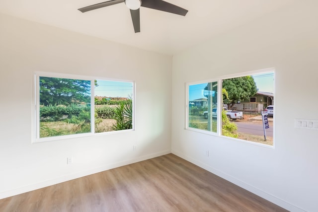 spare room featuring a healthy amount of sunlight, hardwood / wood-style floors, and ceiling fan