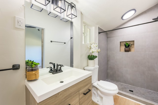 bathroom featuring tiled shower, vanity, toilet, and hardwood / wood-style flooring