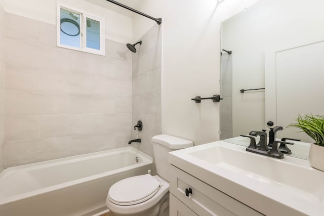 full bathroom with tiled shower / bath, vanity, and toilet