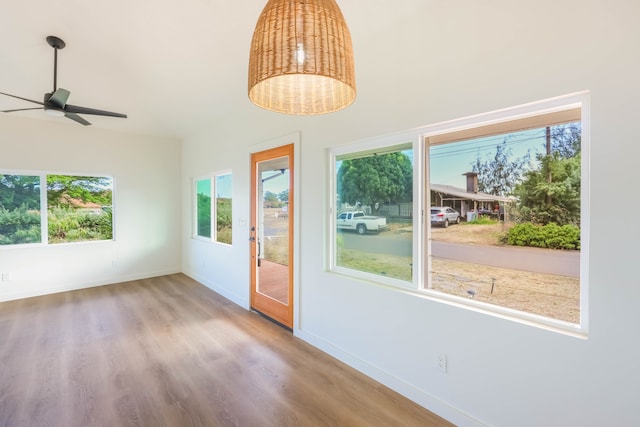 unfurnished sunroom featuring ceiling fan