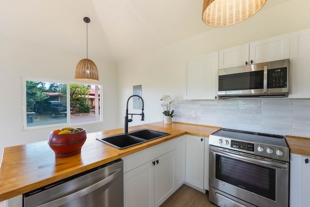 kitchen with sink, white cabinets, stainless steel appliances, decorative light fixtures, and wooden counters