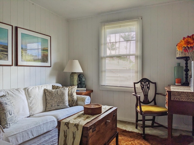 living area featuring a healthy amount of sunlight and wood walls