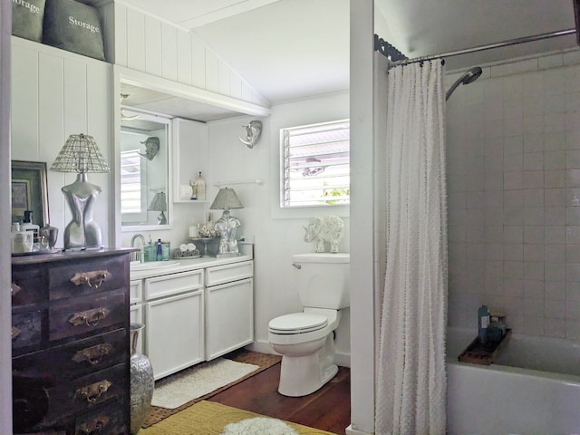 full bathroom with vanity, hardwood / wood-style floors, shower / bath combo, vaulted ceiling, and toilet