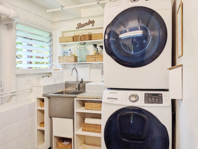 laundry room with stacked washer and dryer and sink