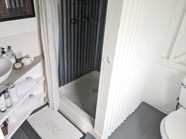 bathroom featuring walk in shower, tile walls, toilet, and tile patterned floors