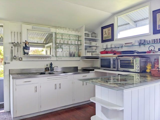 kitchen with vaulted ceiling, sink, kitchen peninsula, dark hardwood / wood-style floors, and white cabinets