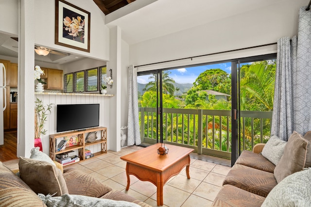 living room with lofted ceiling, a wealth of natural light, and light tile patterned flooring