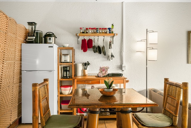 kitchen with white refrigerator and tile patterned floors