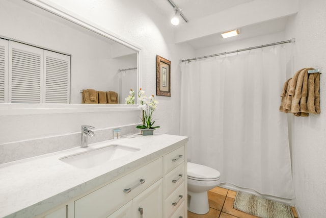 bathroom featuring track lighting, tile patterned floors, toilet, and vanity