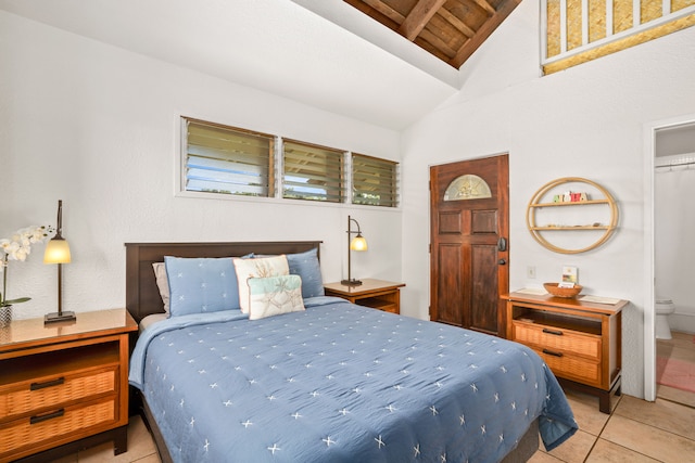 bedroom with vaulted ceiling, a closet, and light tile patterned floors