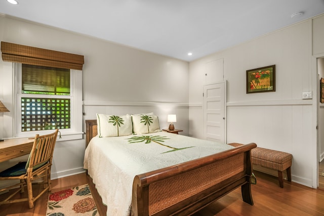 bedroom with wood finished floors, recessed lighting, and an office area
