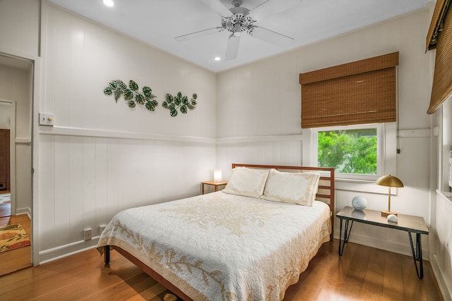 bedroom with hardwood / wood-style floors, a decorative wall, recessed lighting, and ceiling fan