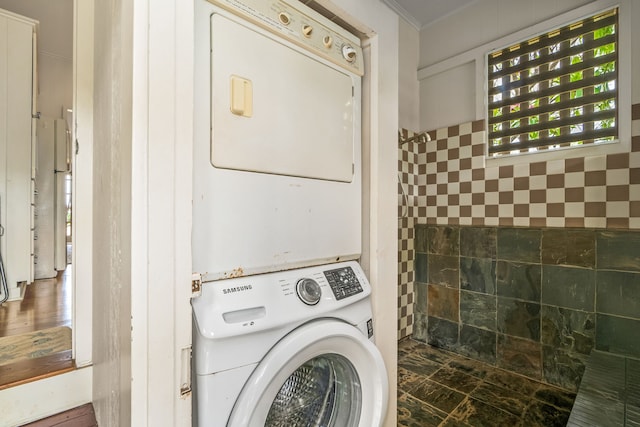 clothes washing area featuring stacked washing machine and dryer
