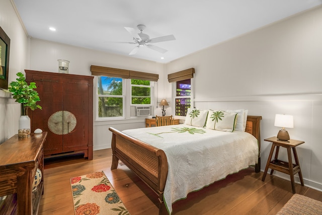 bedroom with wood finished floors, cooling unit, and a ceiling fan