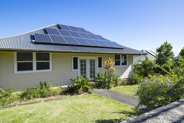 view of front of home featuring solar panels and a front yard