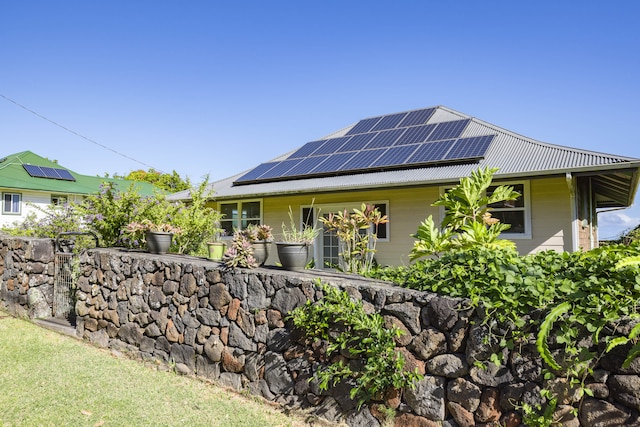 view of side of property featuring solar panels