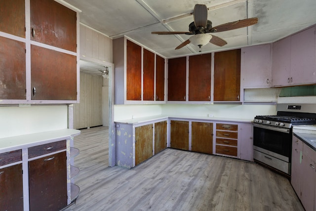 kitchen with light wood-type flooring, gas stove, and ceiling fan