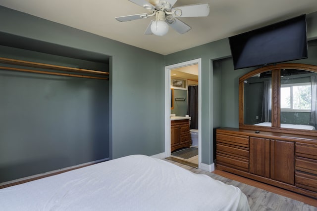 bedroom with a closet, light wood-type flooring, ceiling fan, and connected bathroom