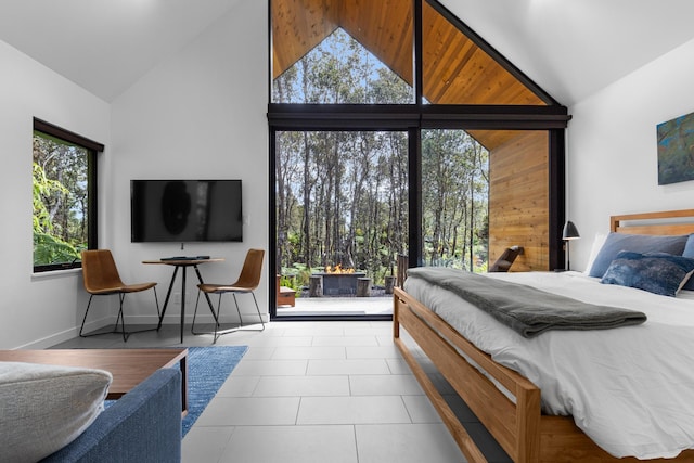 bedroom with light tile patterned floors and high vaulted ceiling