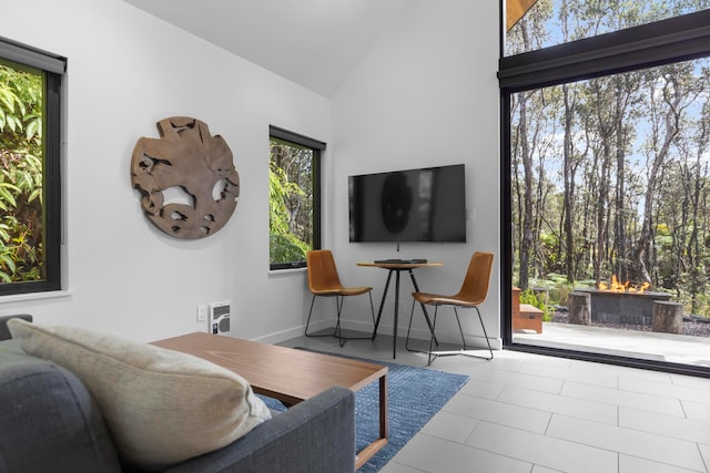 living room featuring high vaulted ceiling, heating unit, and tile patterned flooring