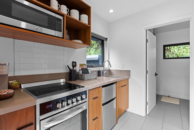 kitchen featuring light tile patterned floors, stainless steel appliances, backsplash, and sink